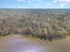 Expansive aerial view of a waterfront property surrounded by lush, mature trees and a glistening lake at 4808 Clubview Ct, Fuquay Varina, NC 27526