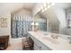 Well-lit bathroom with a large mirror, vanity, and bathtub with shower, designed for comfort and convenience at 4808 Clubview Ct, Fuquay Varina, NC 27526