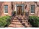 Elegant brick steps lead to a double door entryway with decorative lighting and manicured bushes at 4808 Clubview Ct, Fuquay Varina, NC 27526