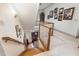 Hallway leading to front door, featuring wooden stairs, light fixtures, and neutral palette at 4808 Clubview Ct, Fuquay Varina, NC 27526