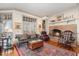 Cozy living room featuring a brick fireplace, comfortable seating, and large windows with natural light at 4808 Clubview Ct, Fuquay Varina, NC 27526
