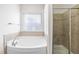 Bright bathroom features a separate shower and tub under a window, offering a spa-like retreat at 4963 Highcroft Dr, Cary, NC 27519