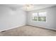 Bedroom with a neutral-colored carpet, a large window, and light-colored walls and ceiling at 514 Peele St # A, Burlington, NC 27215