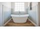 Elegant bathroom featuring a freestanding bathtub, wood look floors, and ample natural light at 6720 Colleen Rd, Rocky Mount, NC 27803