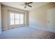 Bright bedroom features a large window and neutral carpeting, with a ceiling fan at 6720 Colleen Rd, Rocky Mount, NC 27803