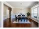 Elegant dining room featuring hardwood floors, a modern chandelier, and a large window providing natural light at 6720 Colleen Rd, Rocky Mount, NC 27803