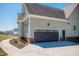 Attached garage with brick foundation, white trim, and a dark wood door; includes adjacent walkway and large parking area at 6720 Colleen Rd, Rocky Mount, NC 27803
