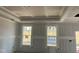 Unfinished bedroom featuring large windows, tray ceiling, and ample natural light at 789 Old Station Pointe, Angier, NC 27501
