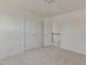 Bedroom with neutral carpet and two doors, one leading to a hallway with stairs at 789 Old Station Pointe, Angier, NC 27501