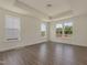 Bedroom featuring luxury vinyl plank flooring, a tray ceiling, and large windows providing ample light at 789 Old Station Pointe, Angier, NC 27501
