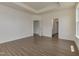 Large bedroom with tray ceiling, wood-look floors and doorways leading to other parts of the home at 789 Old Station Pointe, Angier, NC 27501