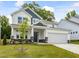 Charming two-story home with stone accents, blue siding, and a well-manicured lawn, showcasing its inviting curb appeal at 789 Old Station Pointe, Angier, NC 27501
