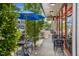 Outdoor seating area with black metal tables and blue umbrellas in front of Anna's Dresses store at 789 Old Station Pointe, Angier, NC 27501