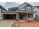 Gray two-story home with attached two-car garage, covered porch, and landscaped yard at 789 Old Station Pointe, Angier, NC 27501