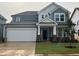 Charming two-story home featuring a two-car garage, a welcoming front porch, and fresh landscaping at 789 Old Station Pointe, Angier, NC 27501