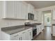 Close-up of the kitchen with stainless steel appliances, granite countertops, and white cabinetry at 789 Old Station Pointe, Angier, NC 27501
