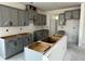 Unfinished kitchen featuring gray cabinets, a center island, and ample storage space at 789 Old Station Pointe, Angier, NC 27501