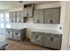 Stylish kitchen featuring gray cabinets, modern hardware, and quartz countertops at 789 Old Station Pointe, Angier, NC 27501