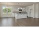Open-concept kitchen with stainless appliances, granite counters, white cabinets, and adjacent living area at 789 Old Station Pointe, Angier, NC 27501