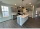 Charming kitchen showcasing gray cabinets, an island, and modern pendant lights at 789 Old Station Pointe, Angier, NC 27501