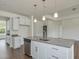 Kitchen island with granite countertops, stainless steel dishwasher, and view into the living area at 789 Old Station Pointe, Angier, NC 27501