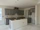 Open-concept kitchen with grey cabinets, island, and abundant natural light, ready for personalization at 789 Old Station Pointe, Angier, NC 27501