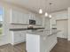 Bright, modern kitchen with stainless steel appliances, granite countertops, and a central island at 789 Old Station Pointe, Angier, NC 27501