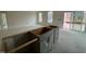 Spacious kitchen showing island, with cabinets and abundant natural light from windows and sliding glass door at 789 Old Station Pointe, Angier, NC 27501