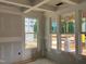 Unfinished living room featuring large windows, tray ceiling, and ample natural light at 789 Old Station Pointe, Angier, NC 27501