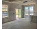 View of unfinished living room showing sliding glass door, large windows, and light-filled space at 789 Old Station Pointe, Angier, NC 27501