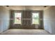 Unfinished living room showcasing drywall, two windows, and natural light at 789 Old Station Pointe, Angier, NC 27501