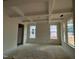 Spacious living room with coffered ceilings and large windows bringing in natural light at 789 Old Station Pointe, Angier, NC 27501