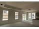 Living room with a coffered ceiling and large windows, with adjacent access to an open kitchen at 789 Old Station Pointe, Angier, NC 27501