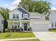 Charming two-story home with a two-car garage, landscaped yard, and blue accents at 789 Old Station Pointe, Angier, NC 27501