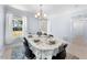 A well-lit dining room has an oval table set for a meal, complemented by a modern chandelier at 916 Clayton Rd, Durham, NC 27703