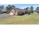 Sprawling brick home showing an attached garage, grilling area, and green lawn at 916 Clayton Rd, Durham, NC 27703