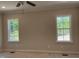 Bedroom with two large windows to let in light and a ceiling fan at 977 Lewis Rd, Zebulon, NC 27597