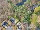 Expansive aerial view highlighting the home's proximity to a wooded area and community lake at 102 Stagville Ct, Cary, NC 27519