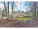 Expansive backyard featuring a deck, sunroom, and lush lawn leading to a wooded area at 102 Stagville Ct, Cary, NC 27519