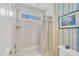 Bathroom featuring white tiled walls, bathtub with shower, and window at 102 Stagville Ct, Cary, NC 27519