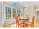 Sun-drenched breakfast nook features large windows and a lovely chandelier at 102 Stagville Ct, Cary, NC 27519