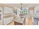Spacious kitchen features an island, granite countertops, stainless steel appliances, and adjacent breakfast nook with backyard view at 102 Stagville Ct, Cary, NC 27519