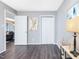 Neutral bedroom with dark flooring, white trim, closet, and bright lighting at 1051 Wirewood Dr # 202, Raleigh, NC 27605