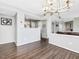 Bright dining area featuring hardwood floors and an elegant chandelier, adjacent to the living room and kitchen at 1051 Wirewood Dr # 202, Raleigh, NC 27605