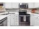 Modern kitchen with stainless steel appliances, white cabinets, and gray countertops at 1051 Wirewood Dr # 202, Raleigh, NC 27605