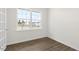 Light-filled bedroom with wood-look flooring and a large window offering outdoor views of the surrounding neighborhood at 108 Pisgah St, Sanford, NC 27330