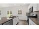 Bright kitchen with granite countertops, stainless appliances, white cabinets, and a large window for natural light at 108 Pisgah St, Sanford, NC 27330