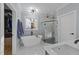 Bright bathroom featuring a modern tub, glass enclosed shower, and marble floors at 110 Black Swan Dr, Youngsville, NC 27596