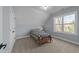 This cozy bedroom has neutral paint, carpet, and a window showcasing a view of the outdoors at 110 Black Swan Dr, Youngsville, NC 27596