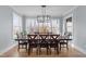 This dining room showcases a wood table, matching chairs, wood floors, an overhead light fixture, and large windows at 110 Black Swan Dr, Youngsville, NC 27596